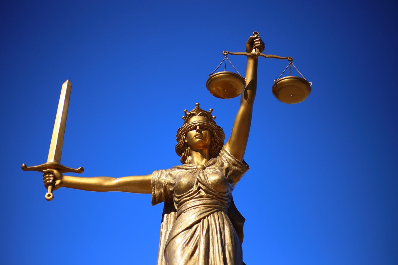 Golden statue of Lady Justice holding scales and sword